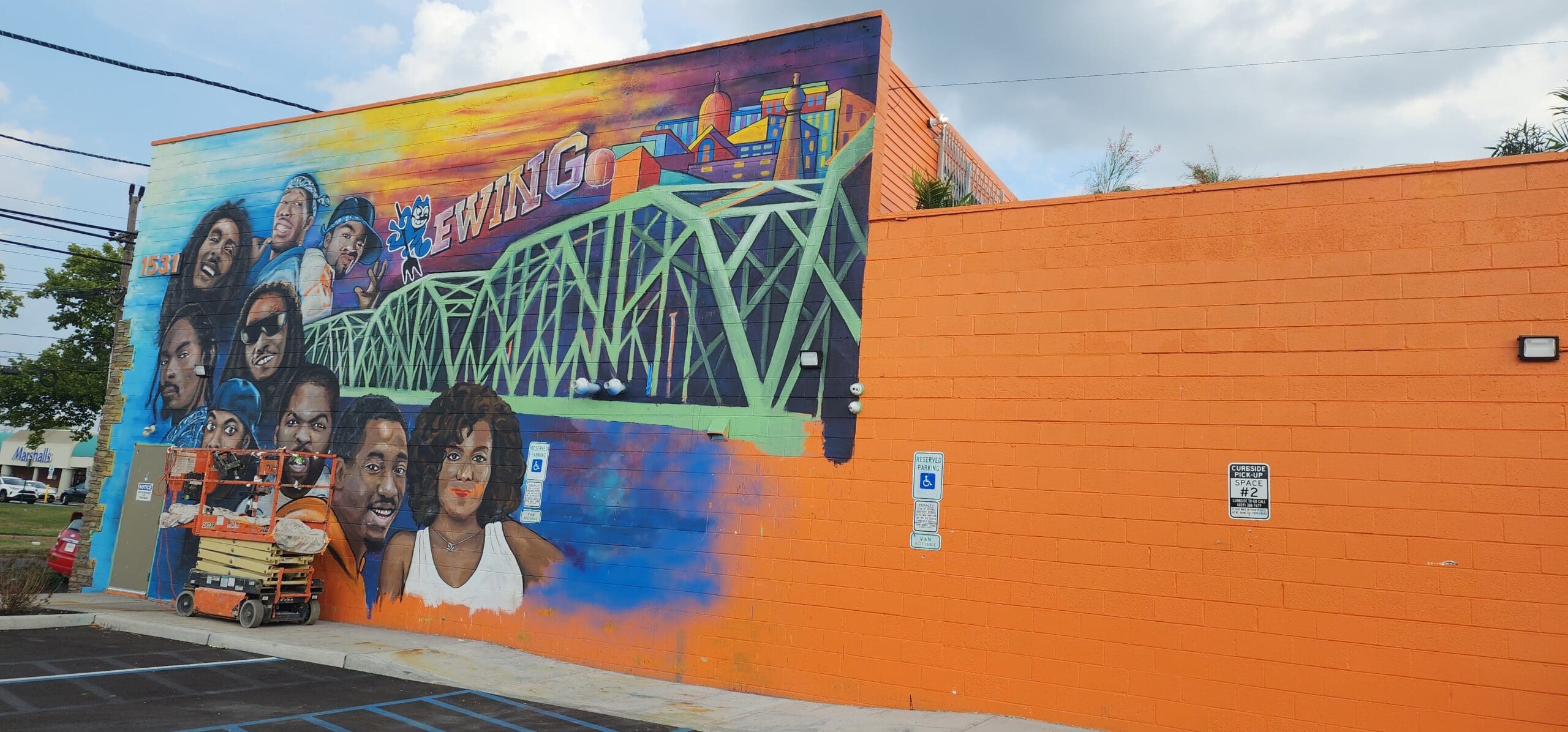 Simply Pure Trenton Dispensary of Ewing pictured with owner Tahir Johnson mural